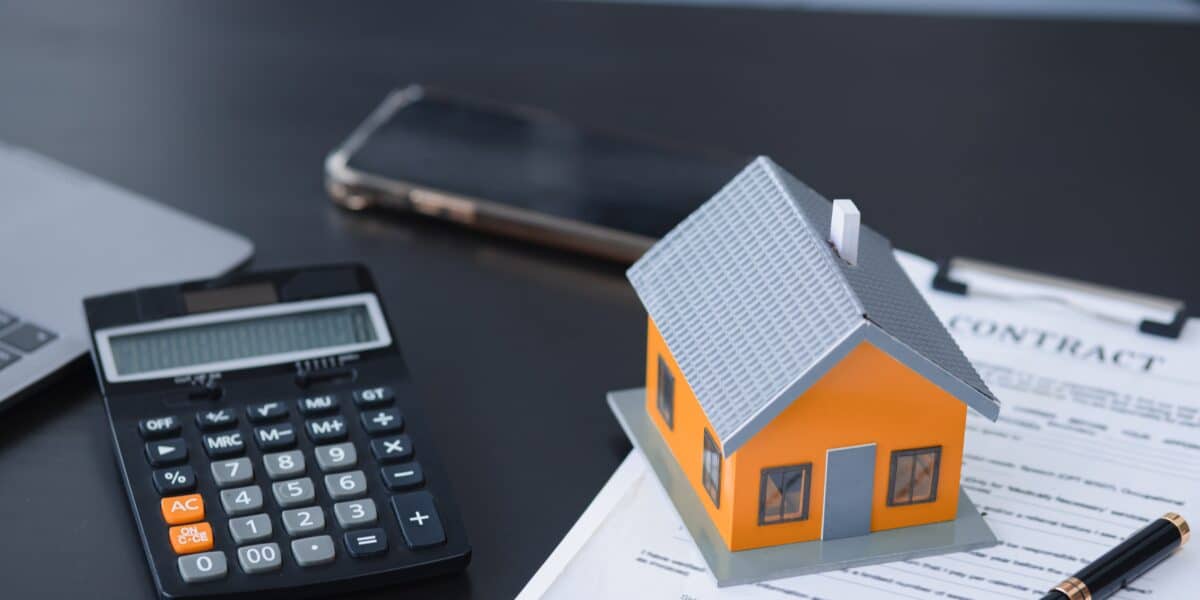 House,Model,And,Calculator,,Real,Estate,Agent,And,Customer,Discussing